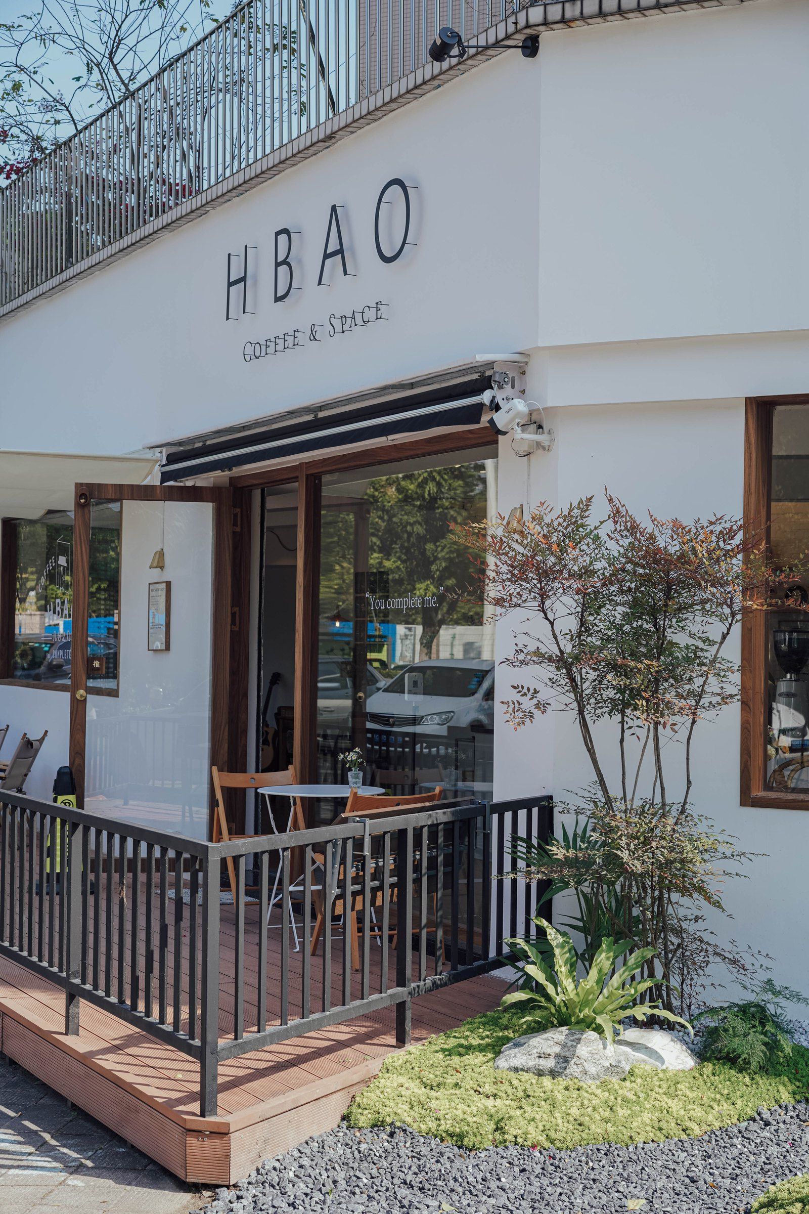 HBAO 门店外墙、入口和露台座位，外墙上可见 HBAO 标识