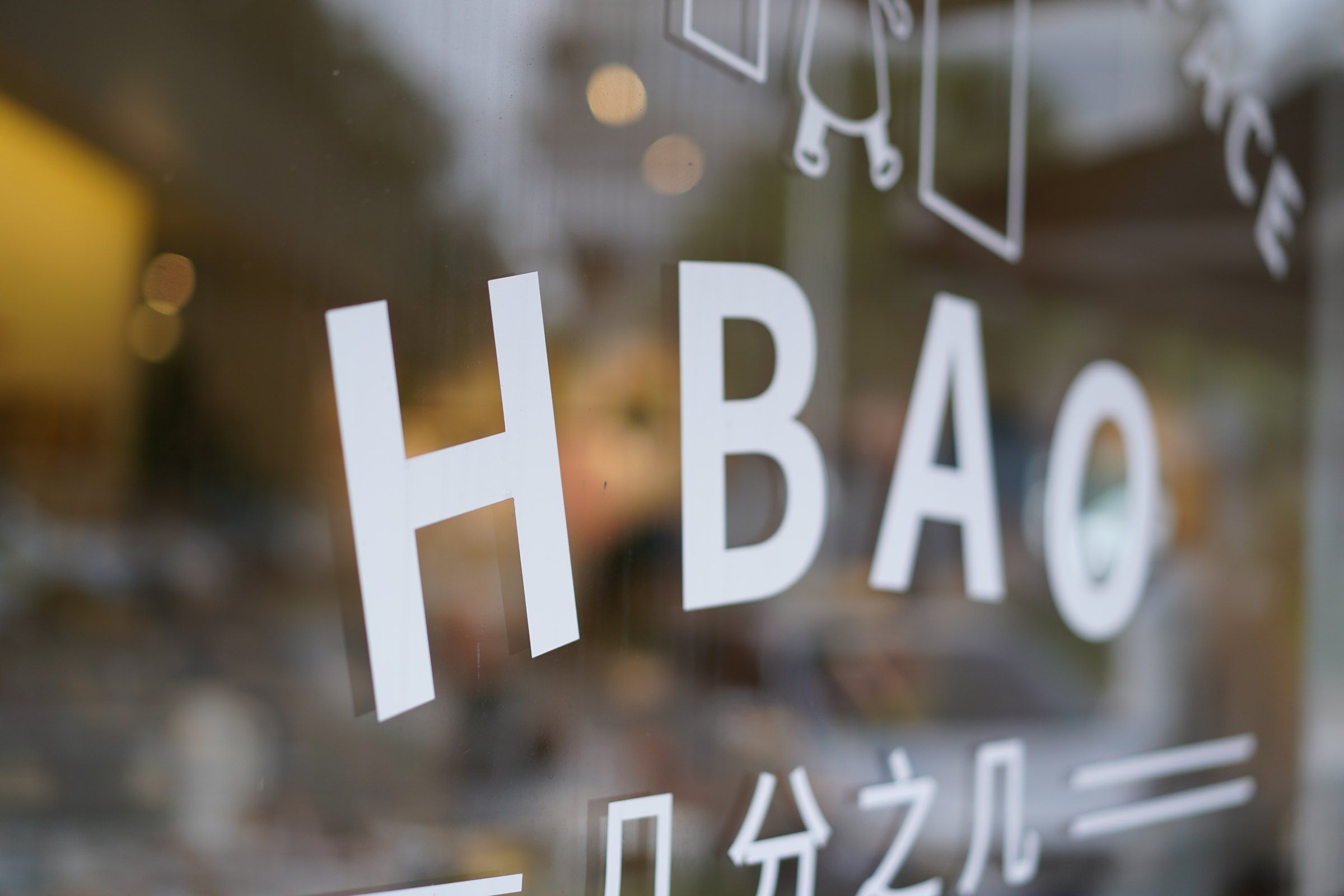 HBAO 门店玻璃上的品牌字样与窗外树影